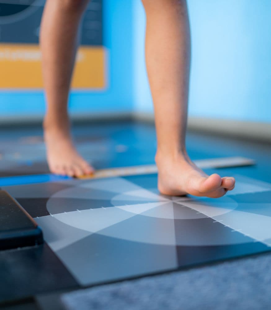 Une personne marche sur un tapis d'analyse plantaire