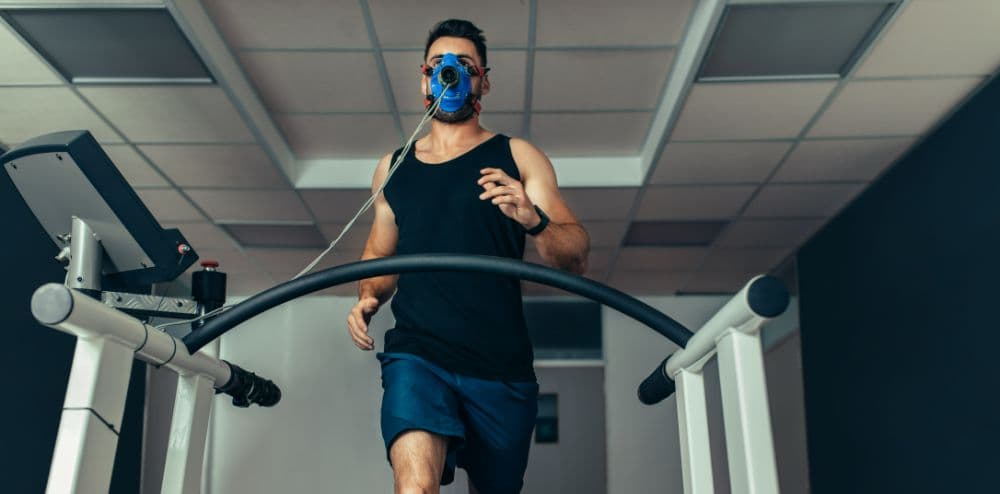 Un homme qui court sur un tapis de course avec un masque VO2